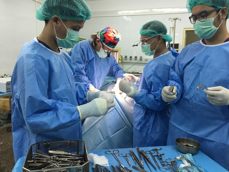 上顎多形成腺腫の手術の様子。ラオス大学口腔外科マスターコースの若手たちが、岩田さんを囲んで熱心に術式を覚える(写真提供:ウィズアウトボーダー)